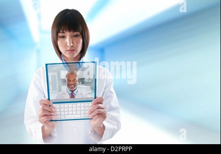 Mixed Race doctor using digital tablet Banque D'Images