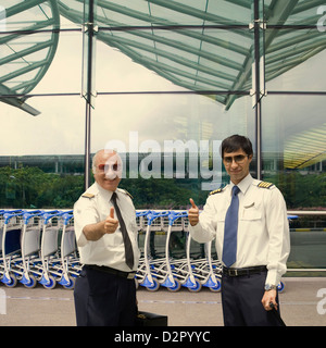 Deux pilotes showing Thumbs up à l'aéroport Banque D'Images