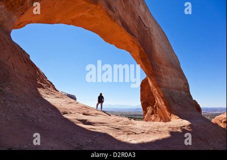 Tourisme au randonneur solitaire Wilson Arch, près de Moab, Utah, États-Unis d'Amérique, Amérique du Nord Banque D'Images