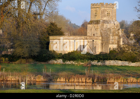 La fin de l'hiver soleil sur St James église normande et rivière Colne, Coln St Dennis, Gloucestershire Banque D'Images