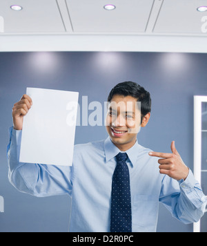 Businessman montrant une feuille de papier vierge Banque D'Images