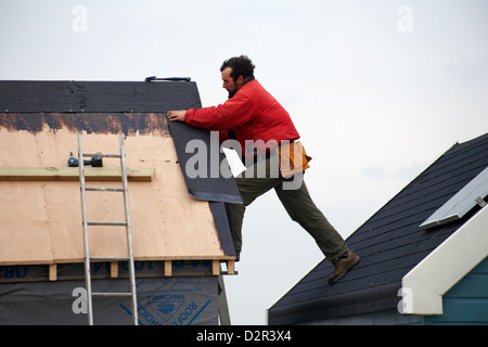 L'homme re-toitures beach hut à Hengistbury Head, Dorset en Janvier Banque D'Images