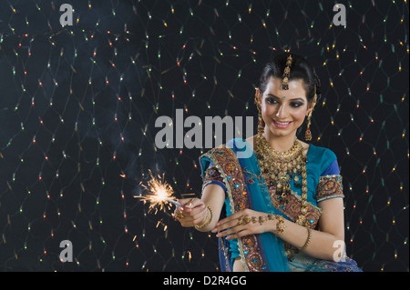 Femme célébrant Diwali festival avec un sparkler Banque D'Images