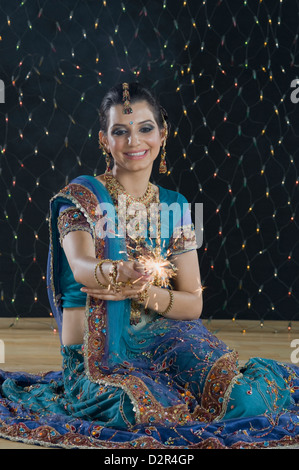 Femme célébrant Diwali festival avec un sparkler Banque D'Images
