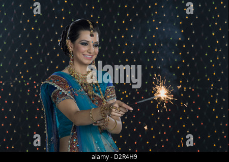 Femme célébrant Diwali festival avec un sparkler Banque D'Images