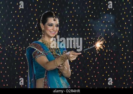 Femme célébrant Diwali festival avec un sparkler Banque D'Images