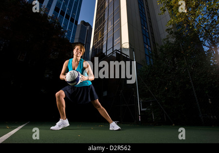 Le netball joueur sur terrain urbain holding ball Banque D'Images