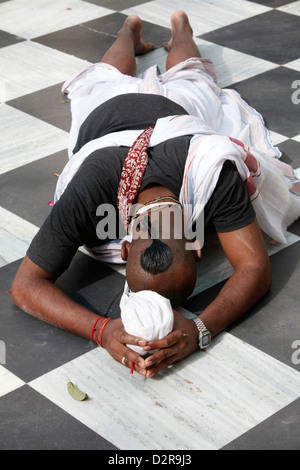 Dévot Hare Krishna se prosternant sur le sol du temple, Vrindavan, Uttar Pradesh, Inde, Asie Banque D'Images