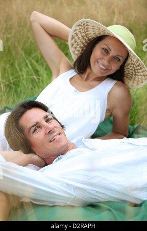40 ans l'homme et de la femme se détendre et couché dans un pré Banque D'Images
