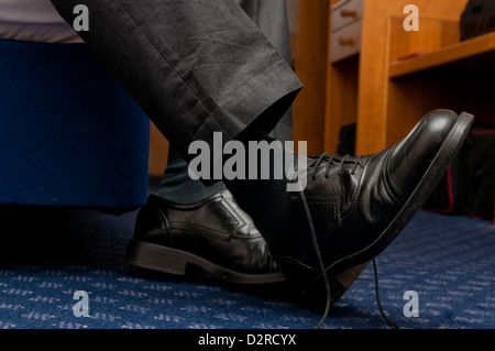 Un homme d'affaires fatigué qui retire ses chaussures dans la chambre  d'hôtel Photo Stock - Alamy