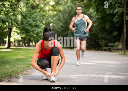 Jeune femme sport lacet, liant l'homme à l'origine est le jogging Banque D'Images