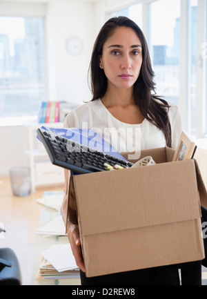 Caucasian businesswoman transportant des articles personnels Banque D'Images