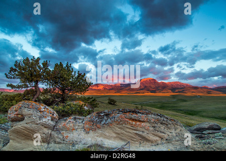 Fiery sunrise la lumière frappe le long de la montagne de l'oreille avant de Rocky Mountain près de Choteau, Montana, USA Banque D'Images