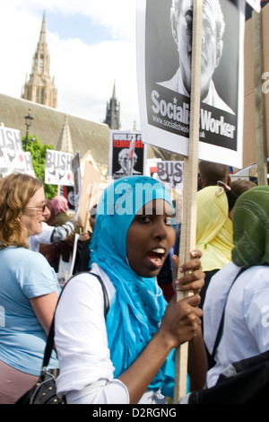 Une femme musulmane noire contient jusqu'manifestant un signe de protestation lors d'une manifestation dans le centre de Londres au Royaume-Uni. Banque D'Images