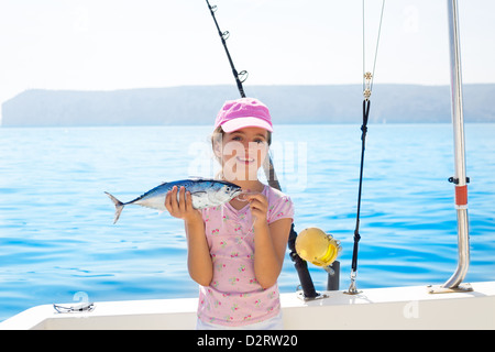 La petite fille dans la pêche au thon peu holding bateau pêche au thon avec la tige et les moulinets de pêche à la traîne Banque D'Images