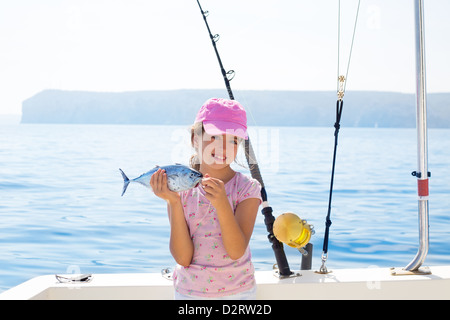 La petite fille dans la pêche au thon peu holding bateau pêche au thon avec la tige et les moulinets de pêche à la traîne Banque D'Images