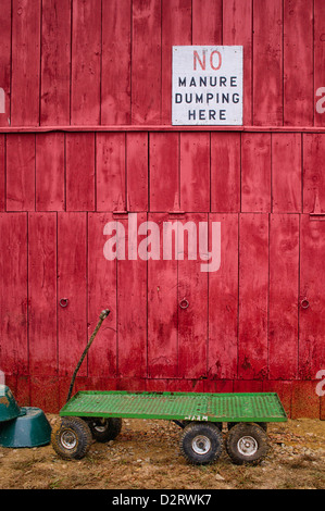 Panneau blanc aucun dumping fumier ici sur mur de la grange rouge Banque D'Images