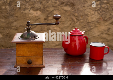 Moulin à café ancien retro vintage avec théière et tasse rouge Banque D'Images