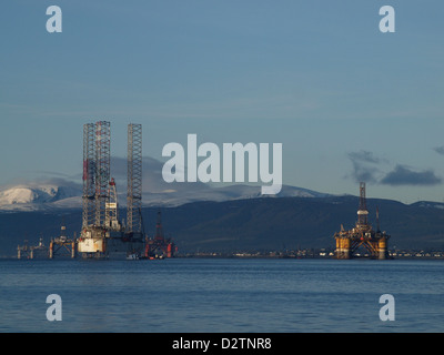 Plates-formes pétrolières empilés dans l'Estuaire de Cromarty en Écosse, en vertu de montagnes couvertes de neige Banque D'Images