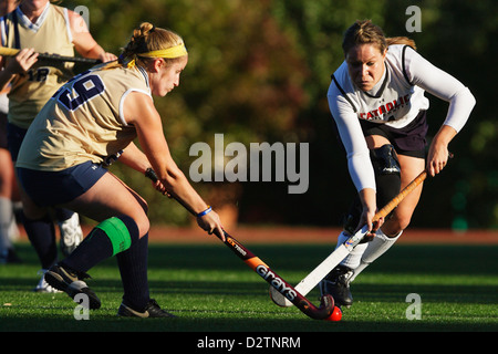 Un joueur de l'Université catholique (R) et lecteur de Juniata College (L) vie de la balle sur le terrain lors d'un match de hockey. Banque D'Images