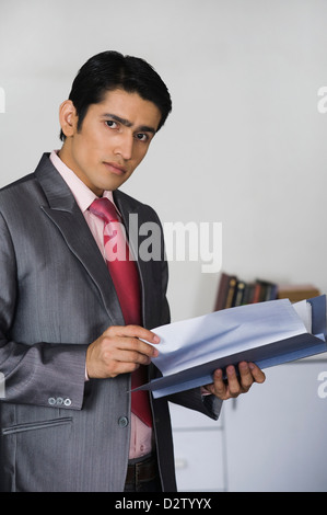 Portrait of a businessman doing paperwork in office Banque D'Images