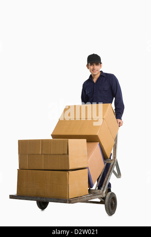 En poussant l'homme livraison de boîtes de carton sur un camion de main Banque D'Images