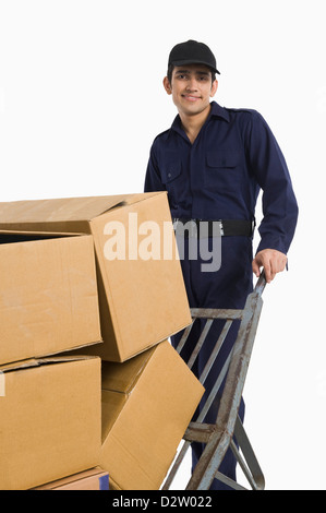 En poussant l'homme livraison de boîtes de carton sur un camion de main Banque D'Images