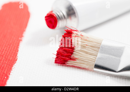 La peinture rouge sur le pinceau avec tube de peinture acrylique et de la peinture sur toile de course Banque D'Images