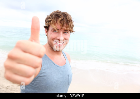 Portrait of happy handsome up signe de réussite au cours de la formation à l'extérieur sur la plage Banque D'Images