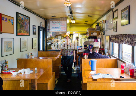 Serveuse pauses pour photographier,vue de l'intérieur de la Cabane de fumée restaurant, situé dans un ancien wagon de chemin de fer, Seward, AK Banque D'Images