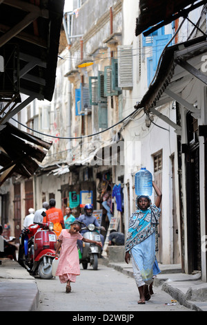 Les gens dans une rue étroite à Stonetown Zanzibar, Tanzanie Banque D'Images