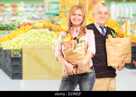 L'homme et la femme dans un supermarché tenant les sacs en papier avec des provisions Banque D'Images