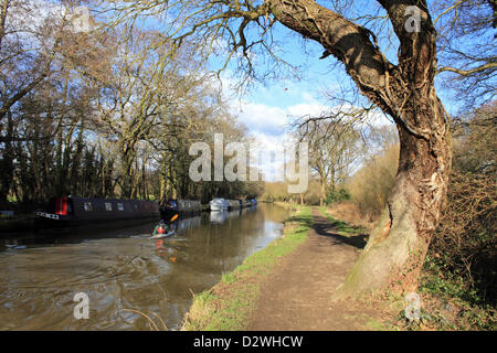 2 février 2013. Ripley, Surrey, Angleterre, Royaume-Uni. Le soleil brille sur une froide journée d'hiver et comme un canoéiste paddles passé bateaux amarrés sur la voie navigable Wey Canal. Banque D'Images