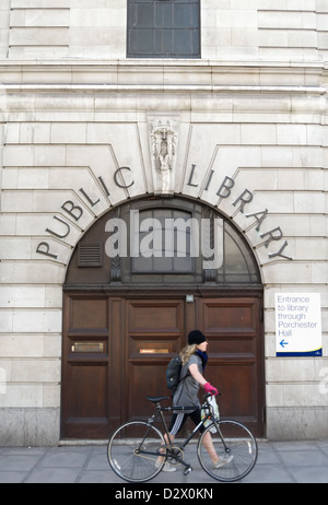 Jeune femme avec un ancien passage vélos marqués d'entrée public library, porchester hall, Bayswater, Londres, Angleterre Banque D'Images