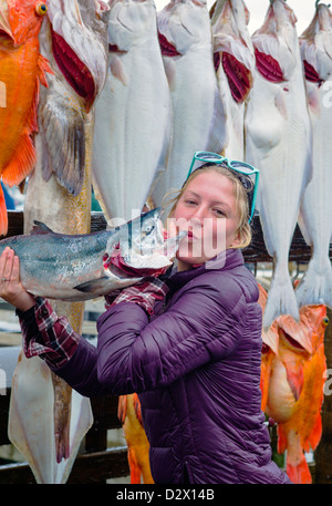 Charter boat fisher woman happily bisous poisson frais du jour pour l'appareil photo, Seward, Alaska, USA Banque D'Images