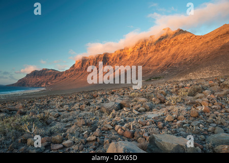 Malpais (terrain accidenté ou avec badlands gommage à sec) en face de la falaise de Famara et plage de Caleta de Famara, Lanzarote Banque D'Images