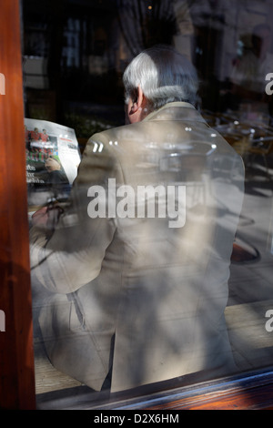 Munich, Allemagne, homme plus âgé assis dans un café et lisant le journal Banque D'Images