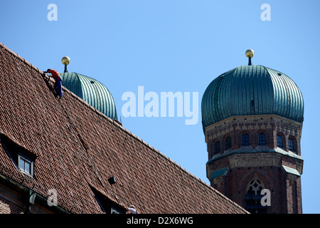 Munich, Allemagne, un homme sur un toit et les tours de la Frauenkirche Banque D'Images