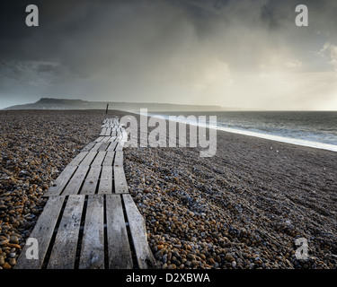 Voir en regardant vers le sud le long de la plage de Chesil vers Portland, Dorset, UK sur un après-midi d'hiver orageux. Banque D'Images