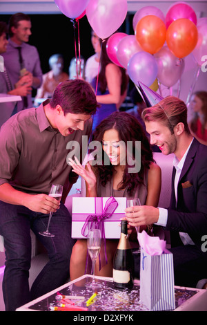 Smiling friends drinking champagne et celebrating birthday in nightclub Banque D'Images