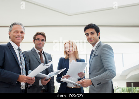 Portrait of smiling business people reviewing paperwork Banque D'Images