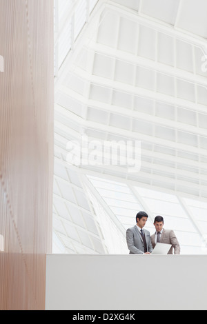 Hommes d'using laptop in modern office Banque D'Images