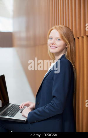 Portrait of smiling businesswoman using laptop Banque D'Images