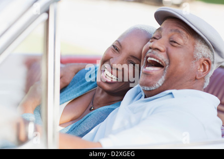 Smiling couple laughing in car Banque D'Images