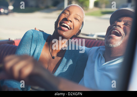 Vieux couple laughing in convertible Banque D'Images