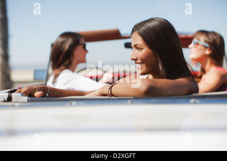 Smiling woman sitting in convertible Banque D'Images