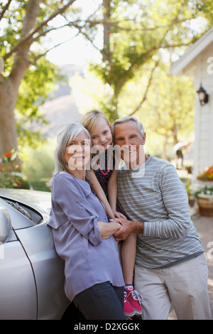 Couple plus âgé et sa petite-fille s'appuyant sur location Banque D'Images