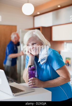 Femme plus âgée à l'aide d'ordinateur portable après entraînement Banque D'Images