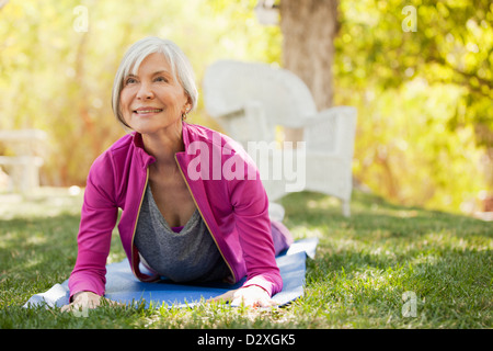 Older woman practicing yoga in backyard Banque D'Images