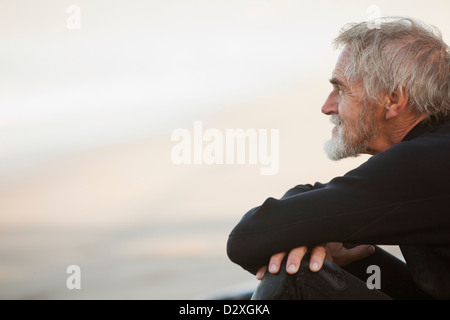 Plus surfer sitting on beach Banque D'Images